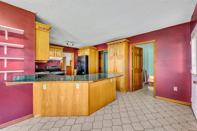 kitchen with dark countertops, under cabinet range hood, a peninsula, electric stove, and black refrigerator with ice dispenser