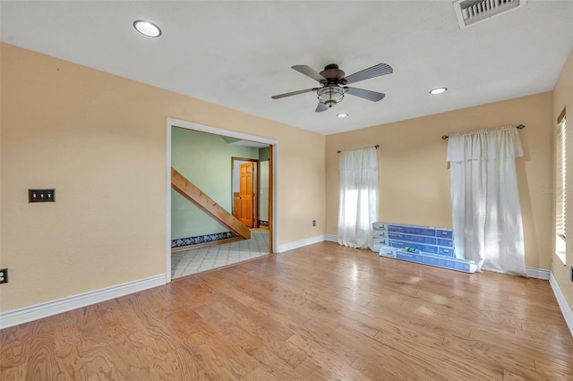 empty room with visible vents, baseboards, and wood finished floors