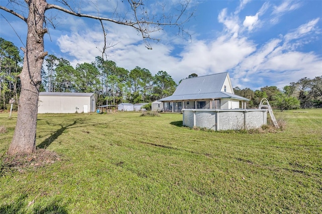 view of yard featuring an outbuilding and an outdoor pool