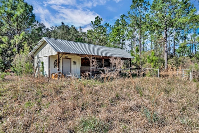 exterior space with an outdoor structure, an outbuilding, a garage, and metal roof