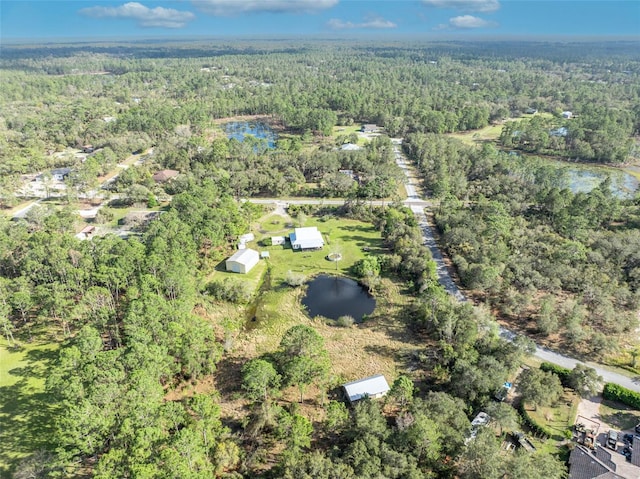 drone / aerial view with a view of trees and a water view