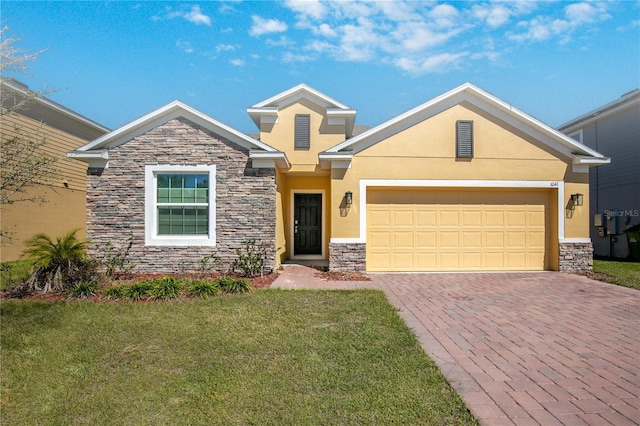 view of front of home featuring stucco siding, a front lawn, decorative driveway, stone siding, and a garage