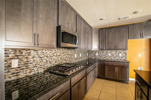 kitchen featuring tasteful backsplash, visible vents, appliances with stainless steel finishes, and dark stone counters