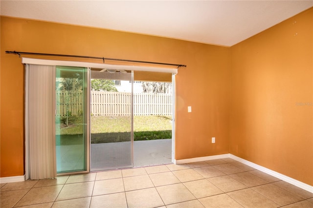 spare room featuring light tile patterned floors and baseboards