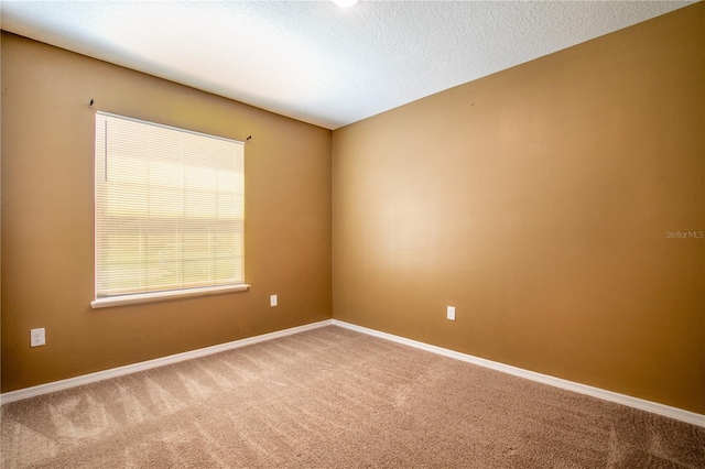 unfurnished room featuring a textured ceiling, baseboards, and carpet floors