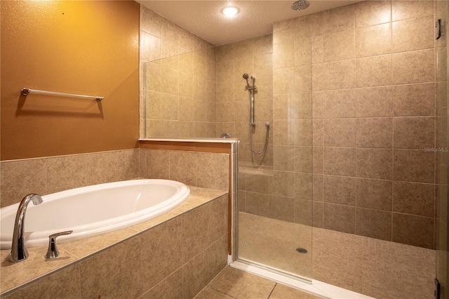 bathroom with a bath, tile patterned flooring, and a tile shower