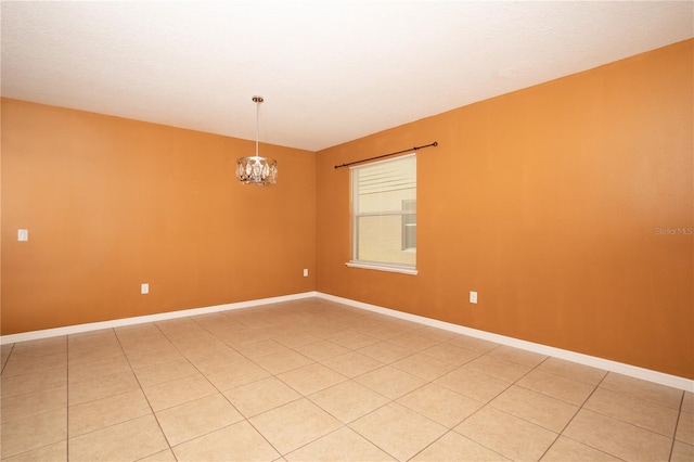 empty room with a notable chandelier and baseboards