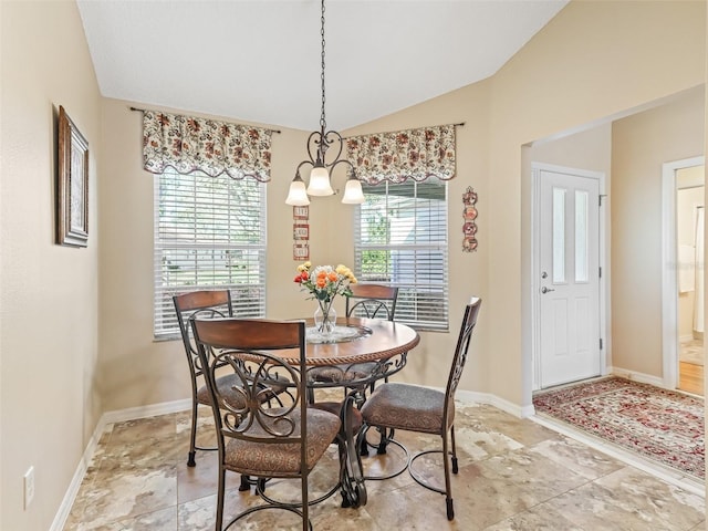 dining space with lofted ceiling, baseboards, and an inviting chandelier