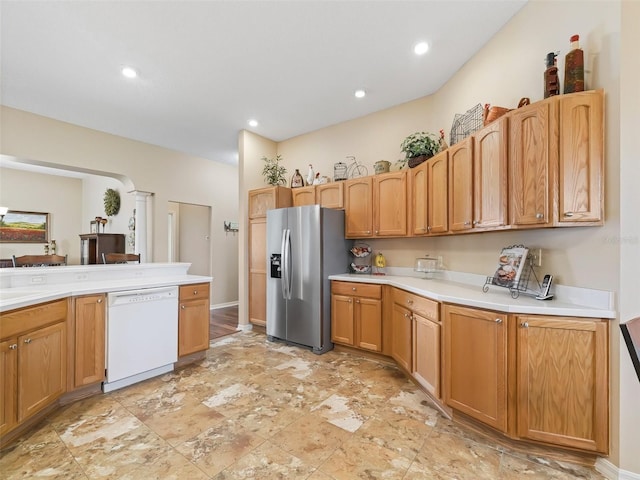 kitchen with stainless steel fridge, arched walkways, dishwasher, light countertops, and recessed lighting