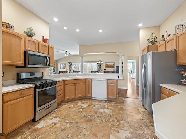 kitchen with a peninsula, appliances with stainless steel finishes, light countertops, and decorative columns