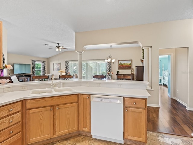 kitchen featuring open floor plan, white dishwasher, a sink, and ornate columns