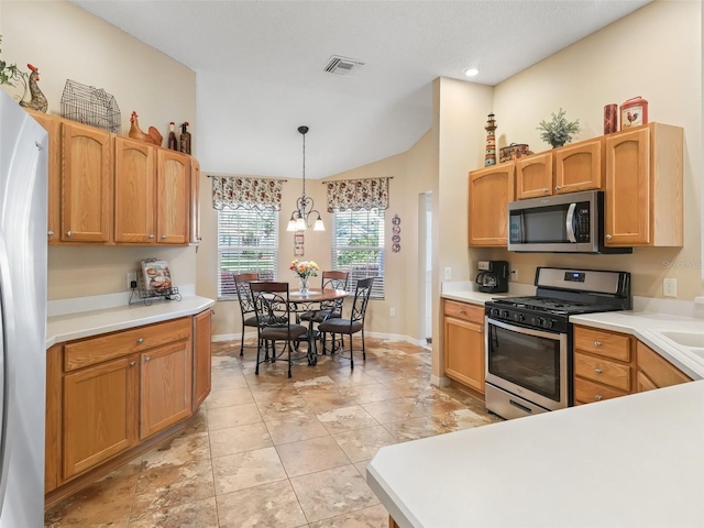 kitchen with visible vents, lofted ceiling, hanging light fixtures, stainless steel appliances, and light countertops