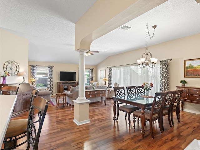 dining area with decorative columns, visible vents, vaulted ceiling, and wood finished floors