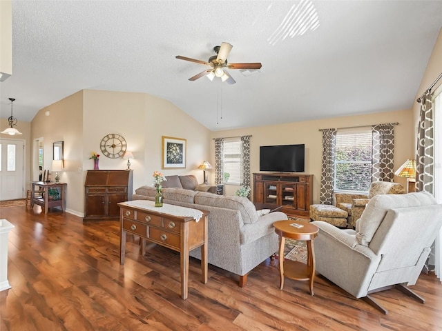 living area featuring lofted ceiling, plenty of natural light, and wood finished floors