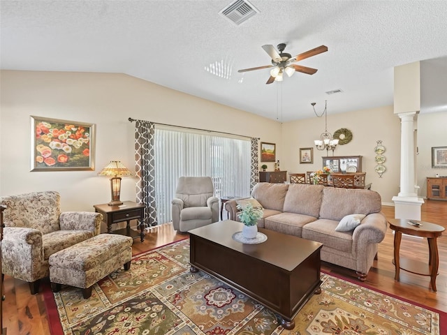 living room with vaulted ceiling, visible vents, decorative columns, and wood finished floors