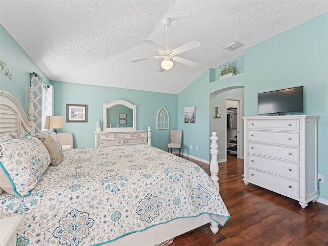 bedroom with ceiling fan, a textured ceiling, vaulted ceiling, and dark wood-type flooring