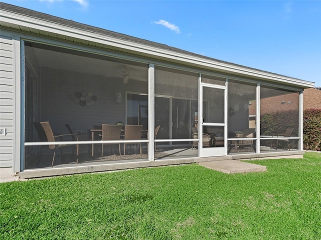 back of house with a lawn and a sunroom