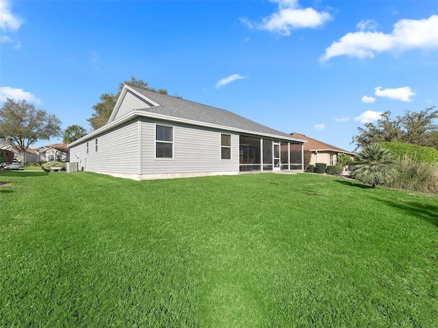 rear view of property featuring a sunroom and a lawn