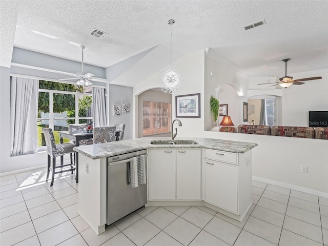 kitchen featuring arched walkways, stainless steel dishwasher, a sink, and visible vents