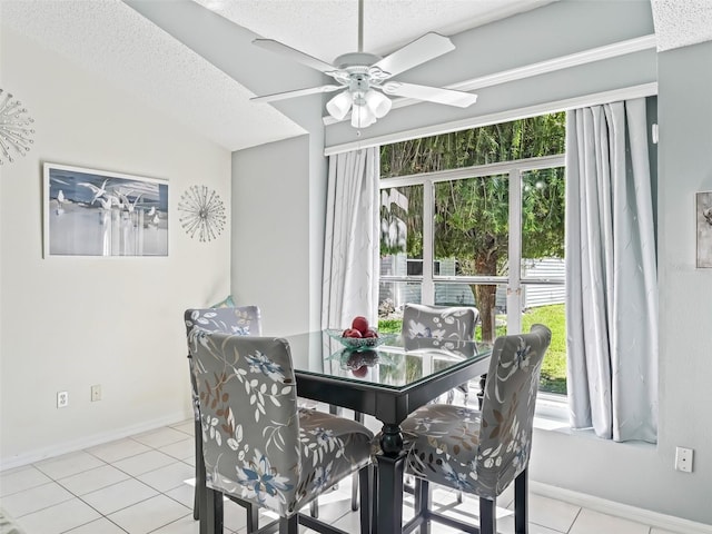 dining room featuring light tile patterned flooring, plenty of natural light, a textured ceiling, and baseboards