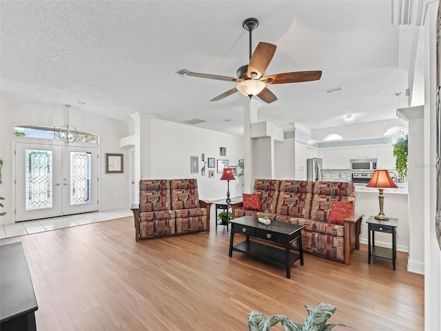 living area with a healthy amount of sunlight, light wood-style floors, and visible vents