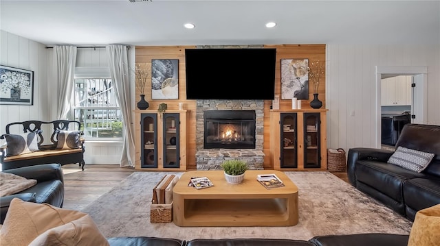 living room featuring a fireplace, wood finished floors, and recessed lighting