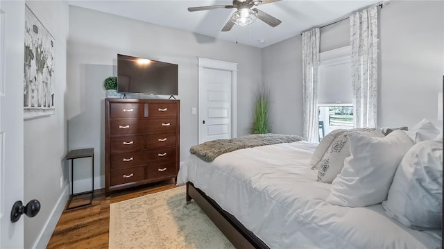 bedroom featuring a ceiling fan, baseboards, and wood finished floors