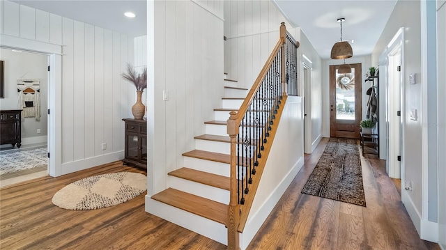 entrance foyer featuring stairway, baseboards, and wood finished floors