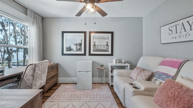 office area with ceiling fan, baseboards, and dark wood finished floors