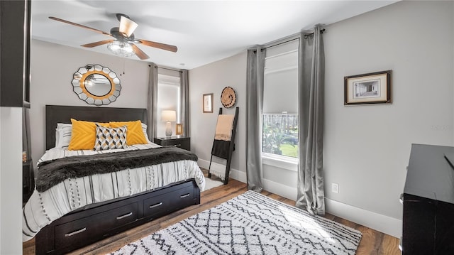 bedroom with ceiling fan, baseboards, and wood finished floors