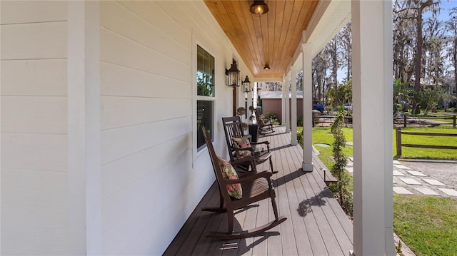 deck with a porch and a yard