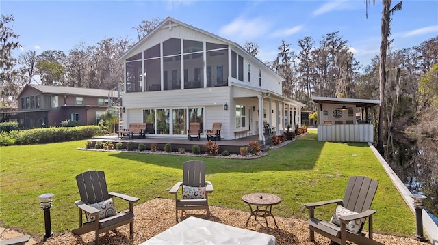 back of house with a yard, a sunroom, and a patio