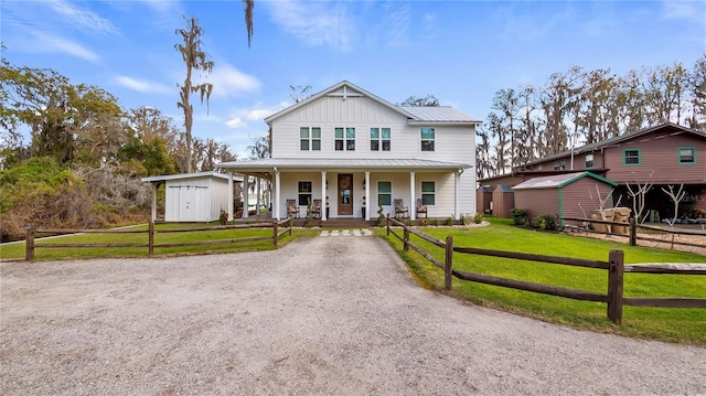 view of front of home featuring a shed, a porch, board and batten siding, and a front lawn