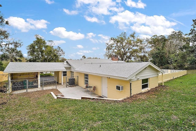 rear view of house with a lawn, central AC, and fence