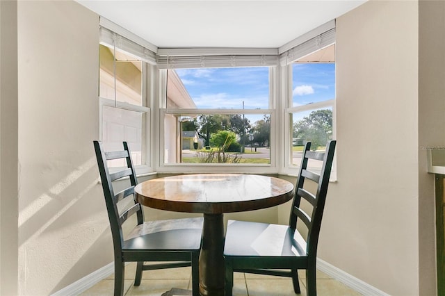 dining space with light tile patterned floors and baseboards