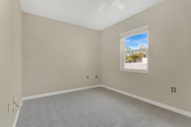 carpeted empty room with a ceiling fan and baseboards