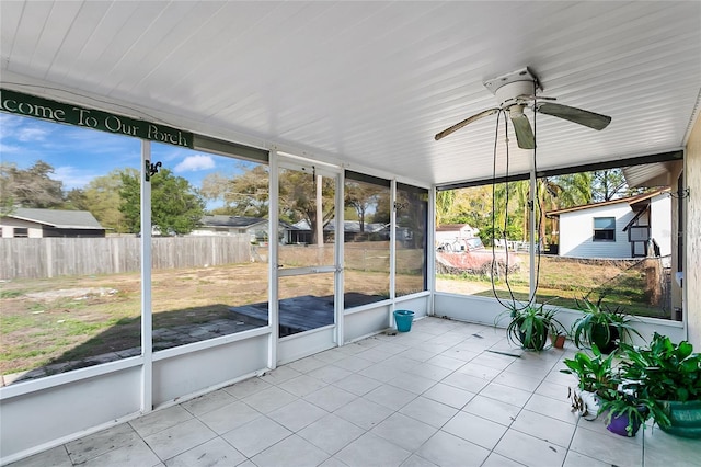 unfurnished sunroom featuring ceiling fan