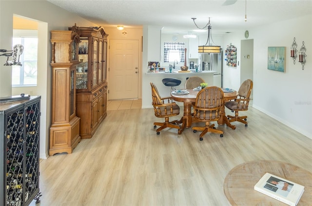 dining space featuring light wood-type flooring and baseboards