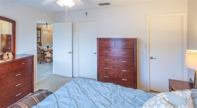 carpeted bedroom with visible vents and a ceiling fan