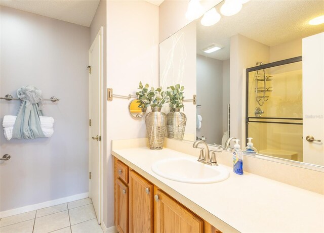 full bath with a stall shower, a textured ceiling, vanity, and tile patterned floors