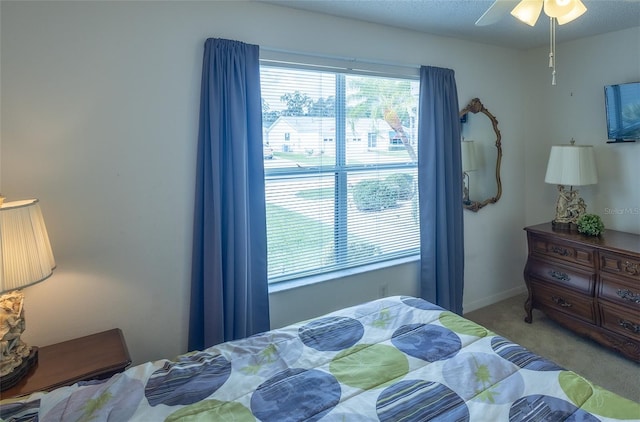 bedroom featuring a ceiling fan, carpet, a textured ceiling, and baseboards