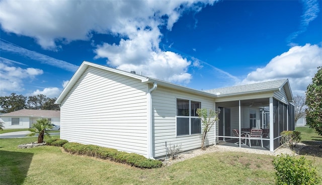 view of property exterior with a yard and a sunroom