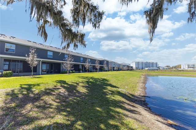 view of property's community featuring a lawn and a water view