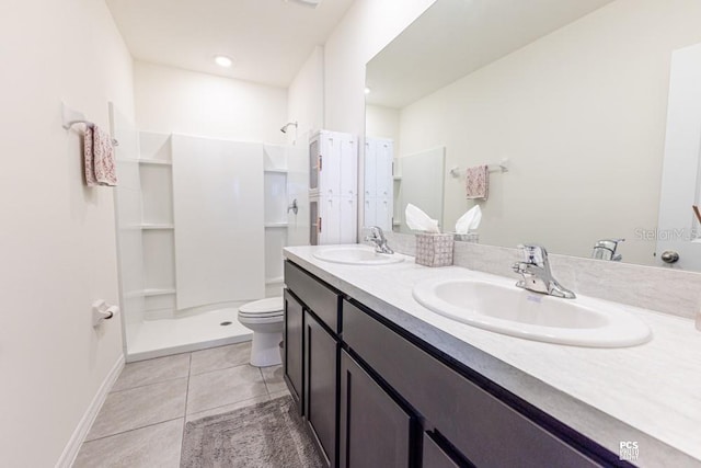 full bath with double vanity, walk in shower, tile patterned flooring, and a sink