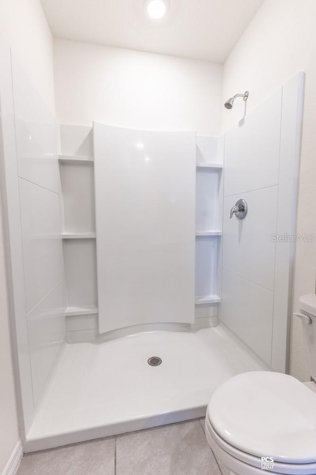 bathroom with a stall shower and toilet