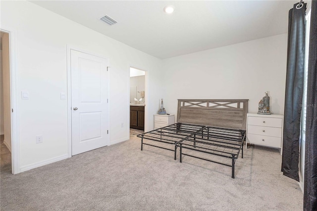 bedroom with baseboards, connected bathroom, visible vents, and carpet flooring