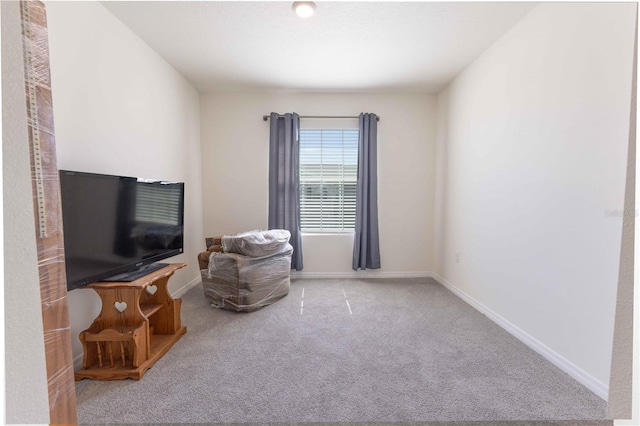 sitting room featuring carpet and baseboards