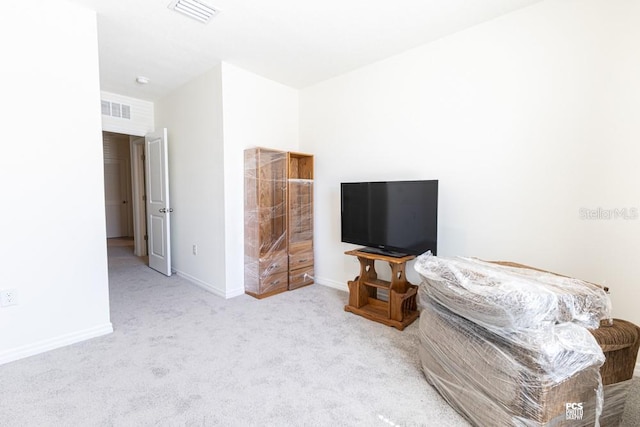 carpeted living area featuring baseboards and visible vents