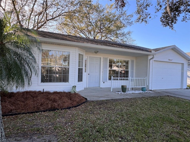 ranch-style home featuring a garage, concrete driveway, a porch, and a front yard