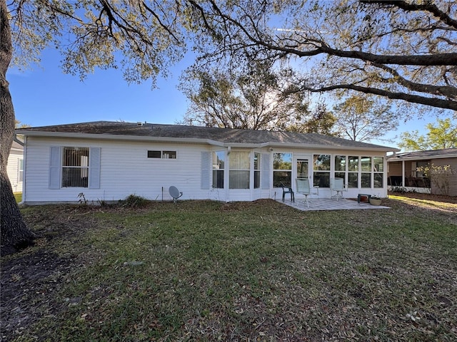 back of property with a sunroom, a lawn, and a patio